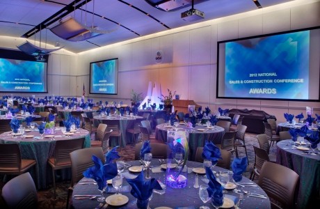 Photo of large conference room with many adorned tables and chairs